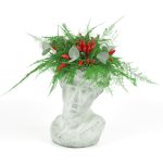 Floral composition on a cassava - head sculpture with peppers and plumose